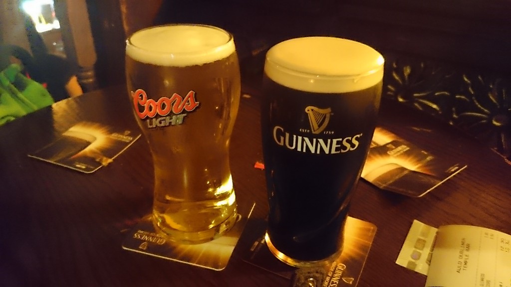 zwei Biergläser in Vordergrund auf einem Tisch in einem Pub